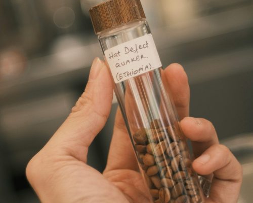 coffee beans in a small glass container with a label